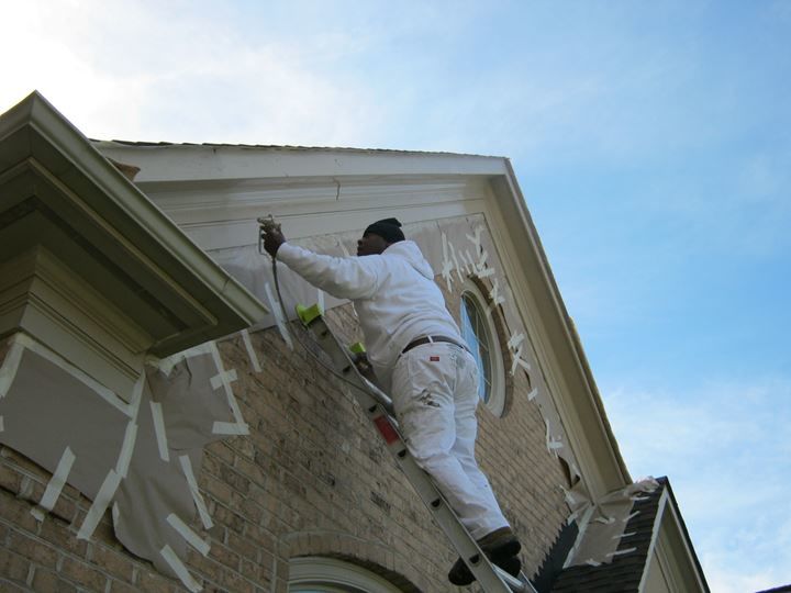 Spray painting exterior eaves on a beautiful home